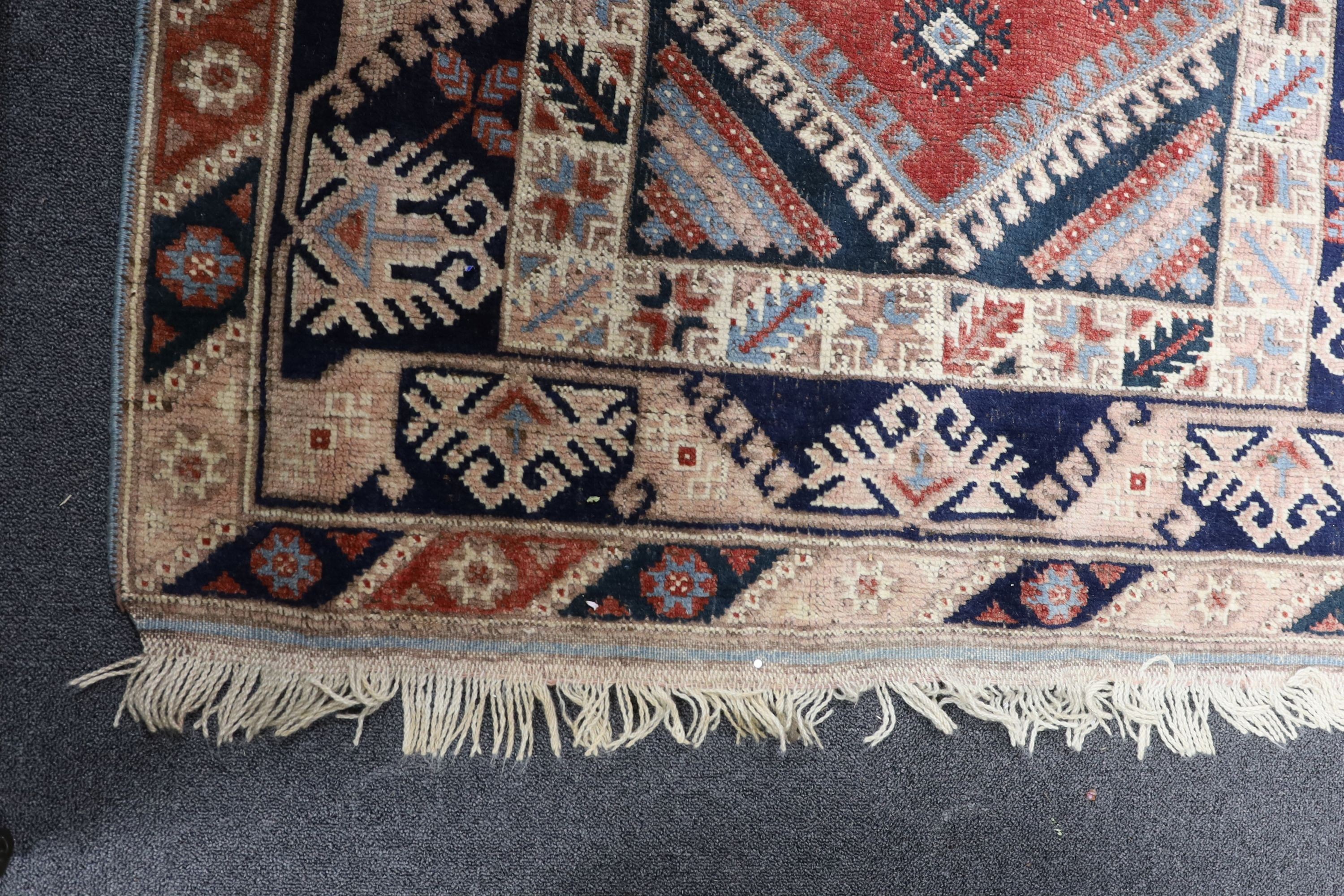 A Caucasian red ground rug and a Bokhara runner, rug 180 x 120 cms